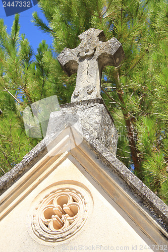 Image of Tombstone with cross ornament at a French cemetery