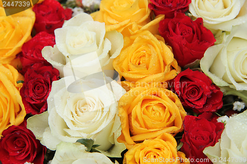 Image of yellow, white and red roses in a wedding arrangement