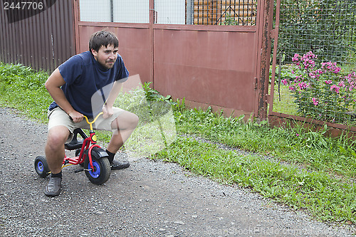 Image of Adult man on a small tricycle