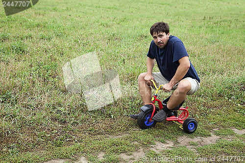 Image of Adult man on a small tricycle