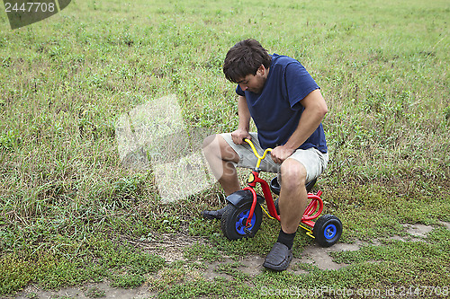 Image of Adult man on a small tricycle