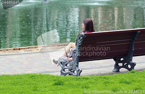 Image of Woman sitting near the lake