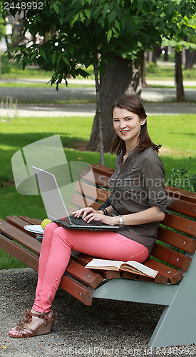Image of Young Woman with a Laptop in a Park