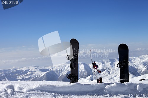 Image of Three snowboards in snow near off-piste slope in sun day