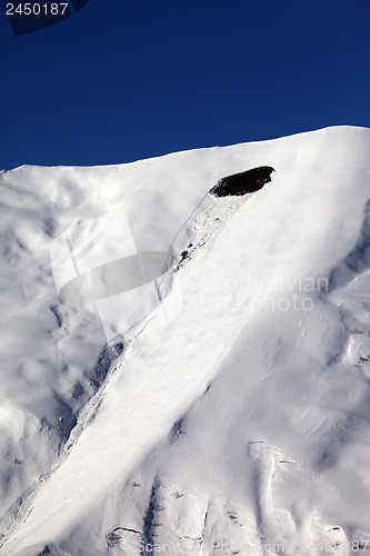 Image of Trace of avalanche on off piste slope in sun day