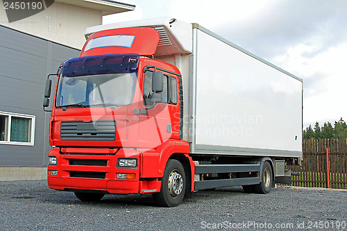 Image of Red Delivery Truck by Warehouse