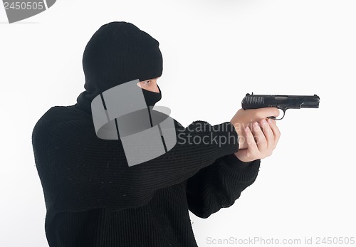 Image of masked man aims with gun