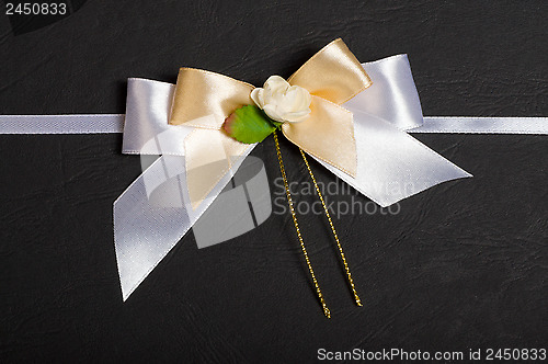 Image of White bow with a flower.