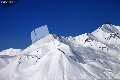 Image of Snowy winter mountains and clear blue sky in sun day