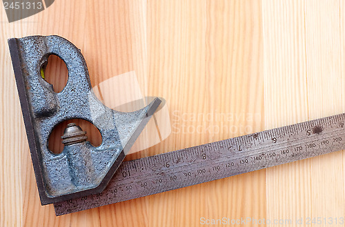 Image of Closeup of metal set square on wood