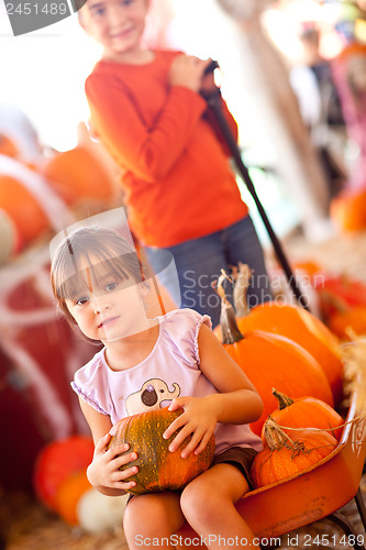 Image of Cute Girl Riding Wagon with Her Pumpkin and Sister