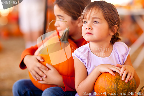 Image of Cute Little Girls Holding Their Pumpkins At A Pumpkin Patch