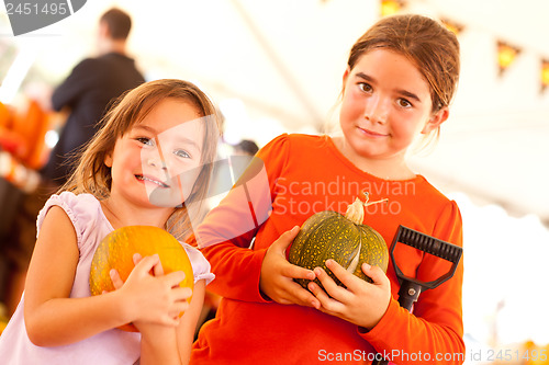 Image of Cute Little Girls Holding Their Pumpkins At A Pumpkin Patch