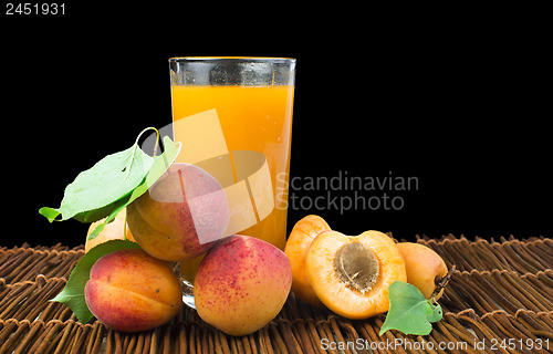 Image of Glass apricot juice and fruits black isolated.