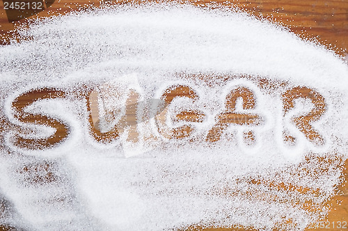 Image of The word sugar written into a pile of white granulated sugar