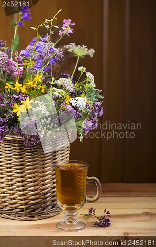 Image of Bouquet of medicinal herbs in basket and herbal tea