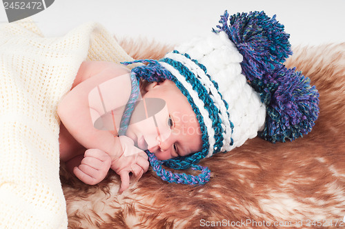 Image of Newborn baby in hat with pom-pom