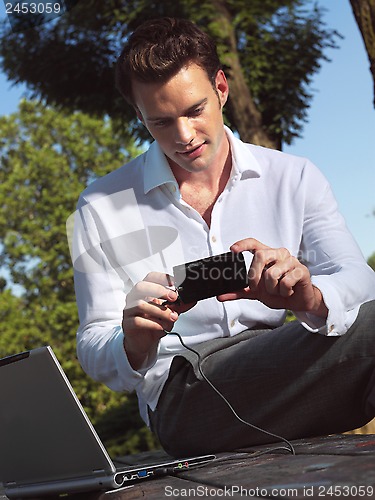 Image of man with camera and laptop e