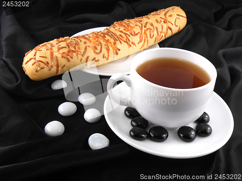 Image of Hot coffee with bread and stones on black background