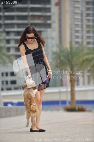 Image of happy young woman with puppy have fun