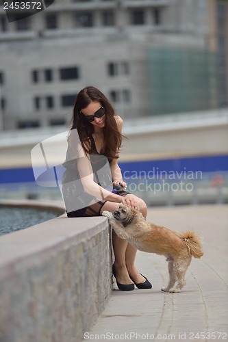 Image of happy young woman with puppy have fun