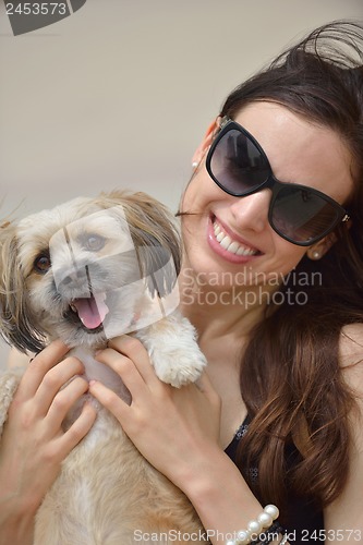 Image of happy young woman with puppy have fun