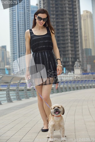 Image of happy young woman with puppy have fun