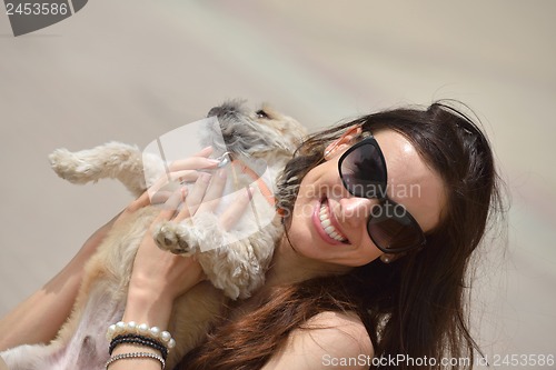 Image of happy young woman with puppy have fun