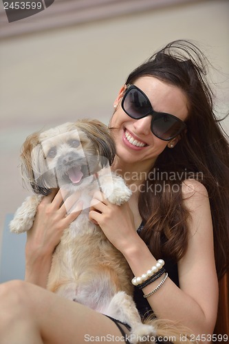 Image of happy young woman with puppy have fun