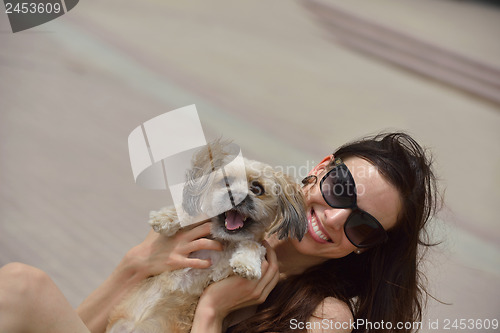 Image of happy young woman with puppy have fun