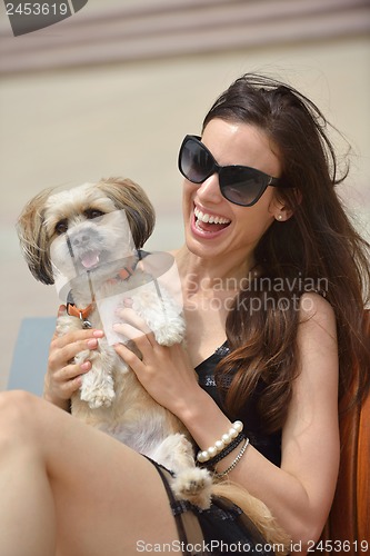 Image of happy young woman with puppy have fun