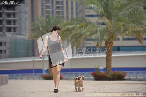 Image of happy young woman with puppy have fun