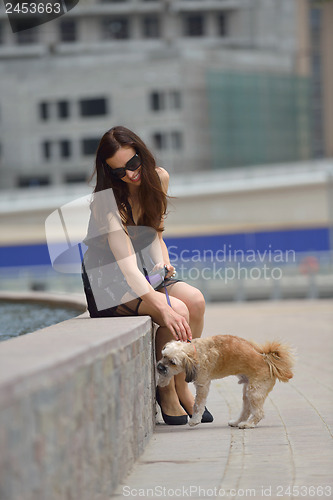 Image of happy young woman with puppy have fun