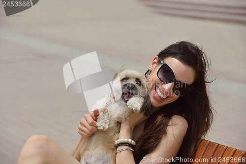 Image of happy young woman with puppy have fun