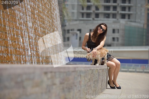 Image of happy young woman with puppy have fun