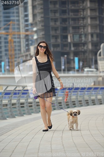 Image of happy young woman with puppy have fun