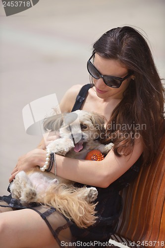 Image of happy young woman with puppy have fun