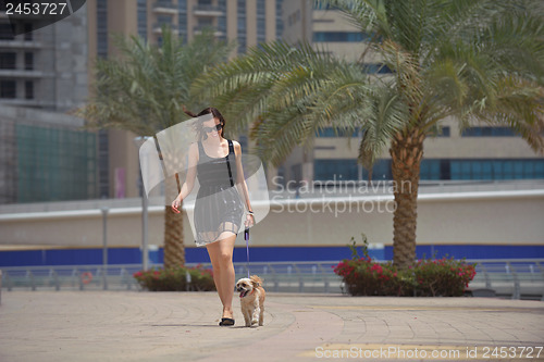 Image of happy young woman with puppy have fun