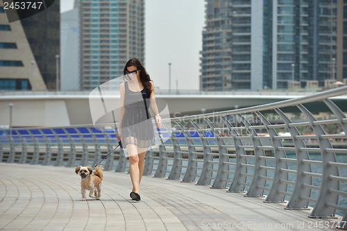 Image of happy young woman with puppy have fun