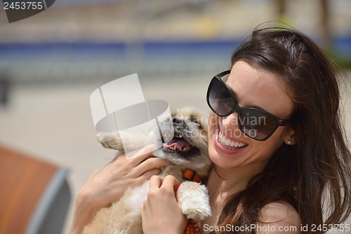 Image of happy young woman with puppy have fun