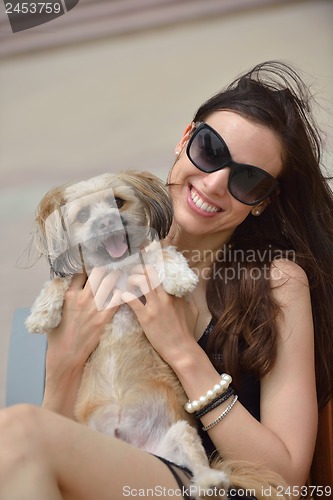 Image of happy young woman with puppy have fun