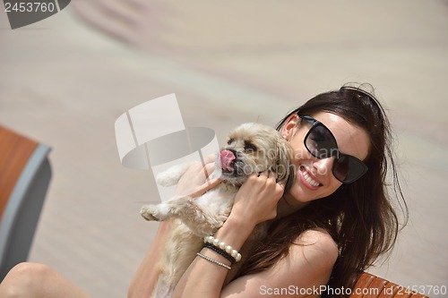 Image of happy young woman with puppy have fun