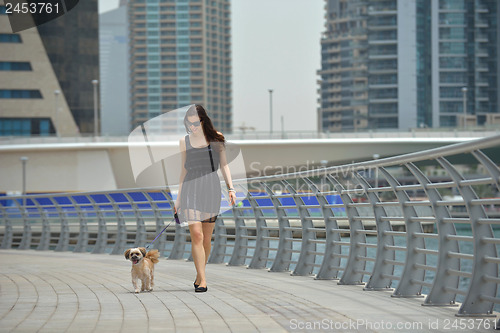 Image of happy young woman with puppy have fun