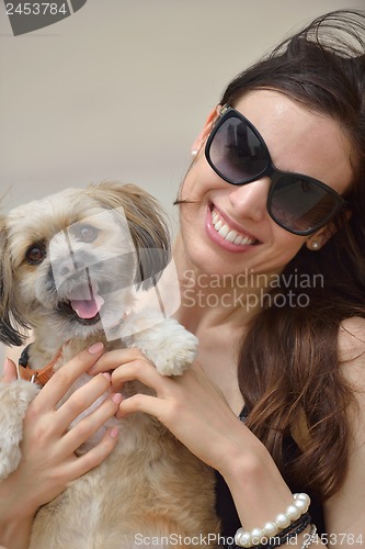 Image of happy young woman with puppy have fun