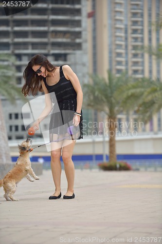 Image of happy young woman with puppy have fun