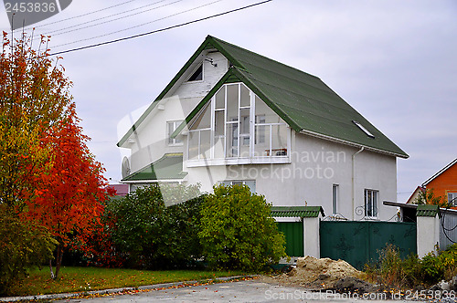 Image of White cottage with a green roof