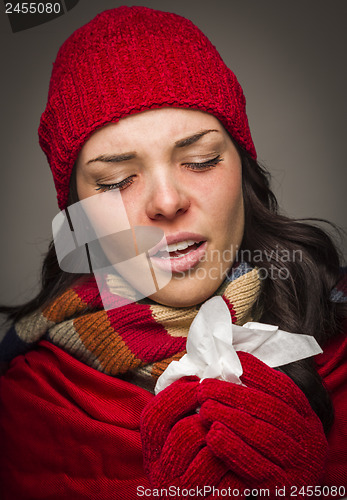 Image of Sick Mixed Race Woman Blowing Her Sore Nose With Tissue