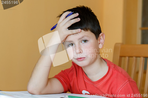 Image of tired and bored boy doing school homework