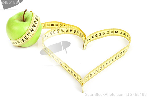 Image of green apple with a measuring tape and heart symbol isolated