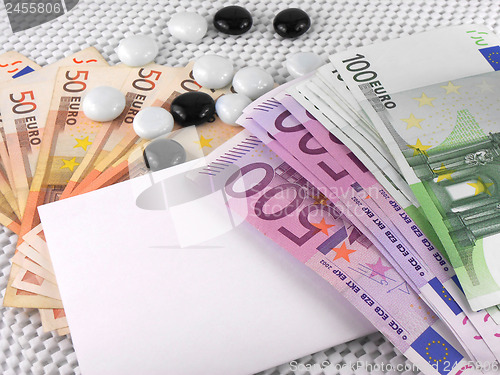 Image of 500 euros currency, white empty paper and stones
